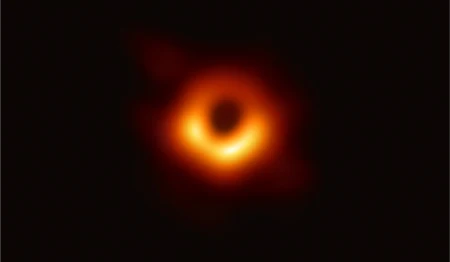 First real image of a black hole, showing a glowing orange ring surrounding a dark central shadow, captured by the Event Horizon Telescope.